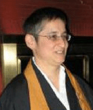 Image of Melissa Myozen Blacker Roshi dressed in robes and speaking